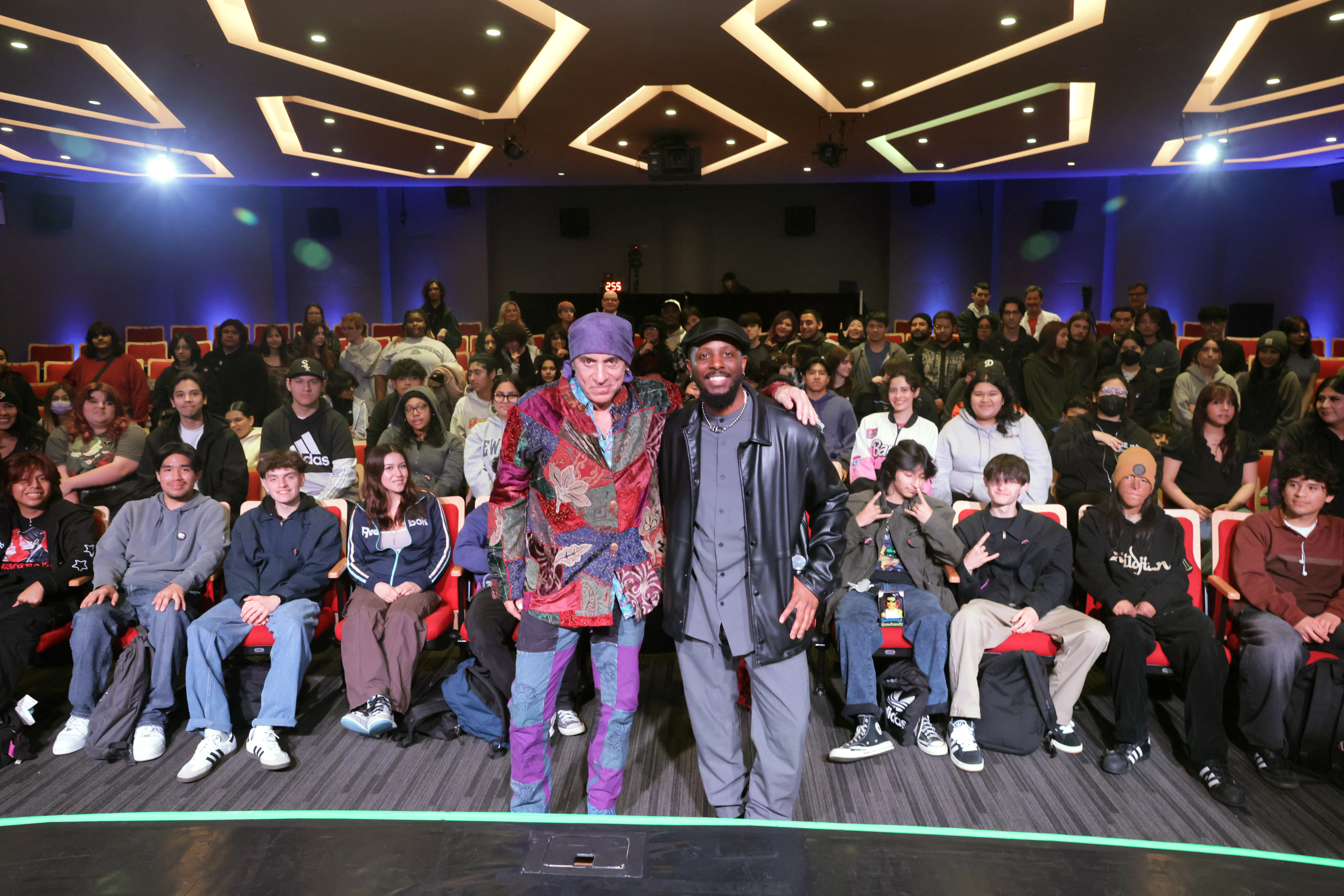 Steven Van Zandt and moderator Schyler O'Neal pose with students at TeachRock Backstage Pass with Steven Van Zandt at the Grammy Museum on April 5, 2024.